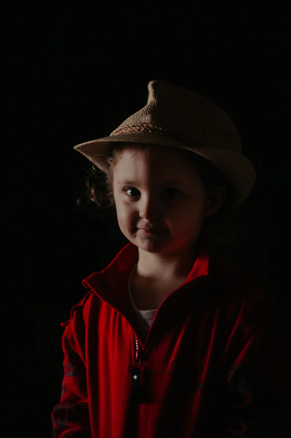 Studio portrait of a very young female child posing in Vienna. The image captures her adorable and playful demeanor in a professional studio setting.