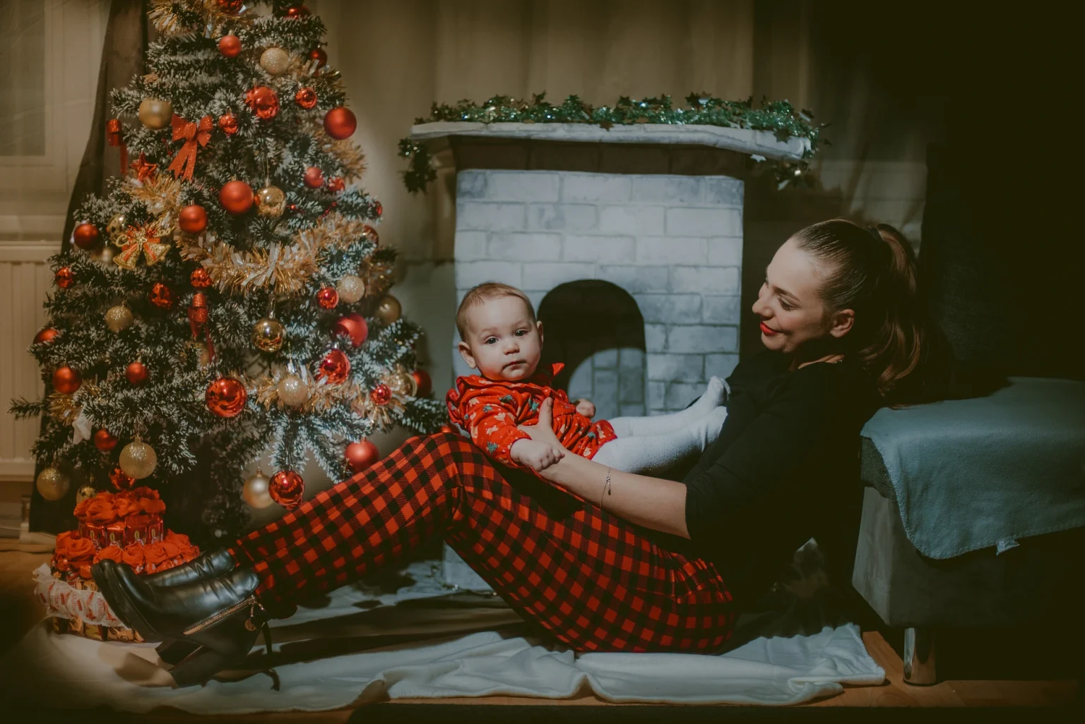 Christmas photoshoot in Vienna featuring a baby and mom in a studio setup. The image captures the festive spirit and the joyful interaction between mother and child.