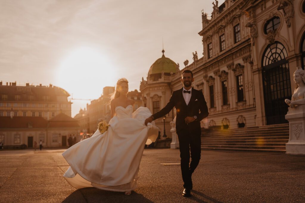 Golden hour wedding portrait at Belvedere Palace in Vienna. The warm sunset light bathes the couple in a romantic glow, with the historic palace providing an elegant backdrop.
