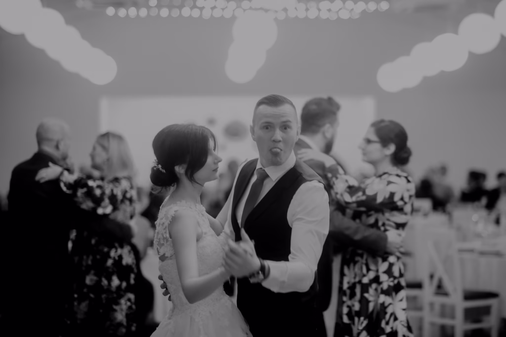 Bride and groom make their grand exit under a sparkling tunnel of lights, holding hands and smiling as they step into a luxurious getaway car, surrounded by glowing guests.Would you like a film-like cinematic variation to enhance the exclusivity?