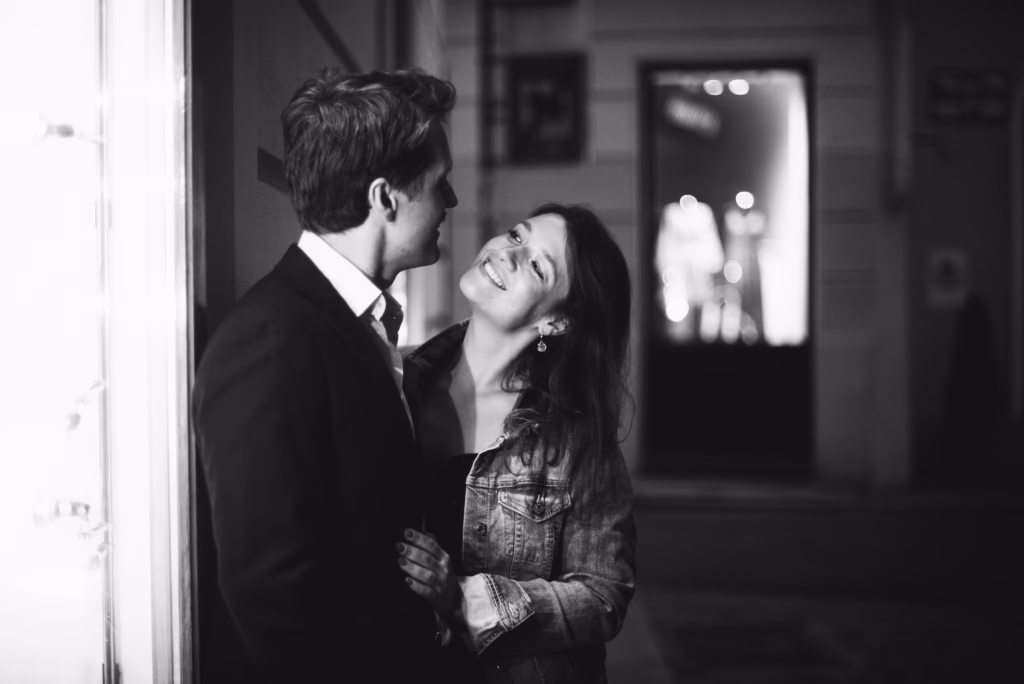 A couple sharing a joyful moment during their engagement session, elegantly posed in a Vienna cityscape, exuding confidence and romance before their wedding day.