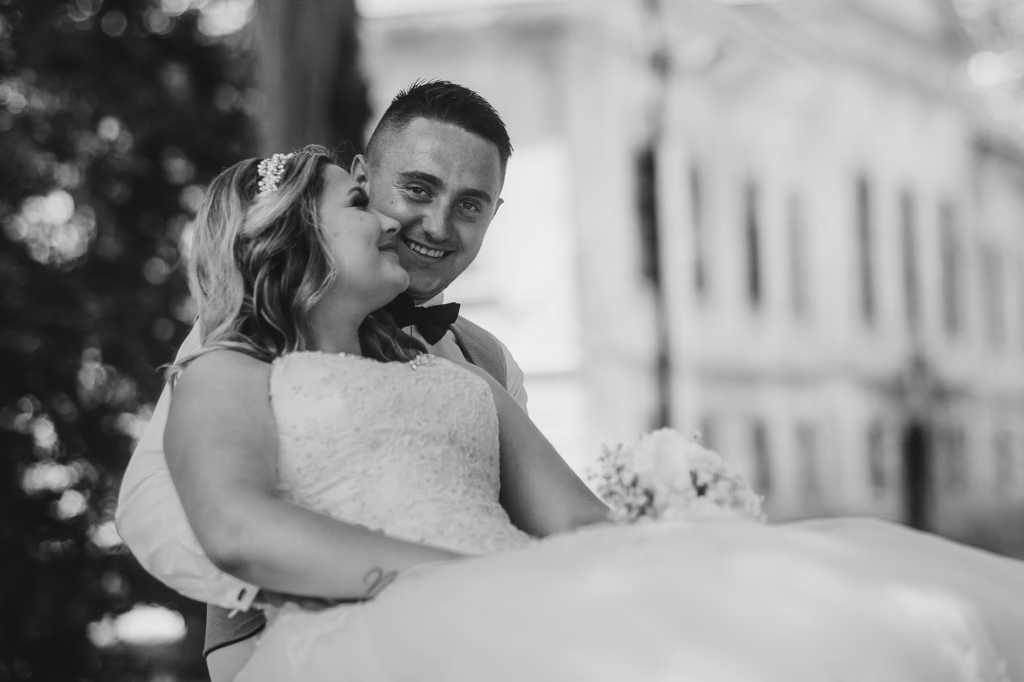 A couple in an intimate embrace in front of Schönbrunn Palace, elegantly dressed, as the golden light enhances the romantic setting of their Vienna elopement.Would you like a list of Vienna’s best elopement venues to complement this?
