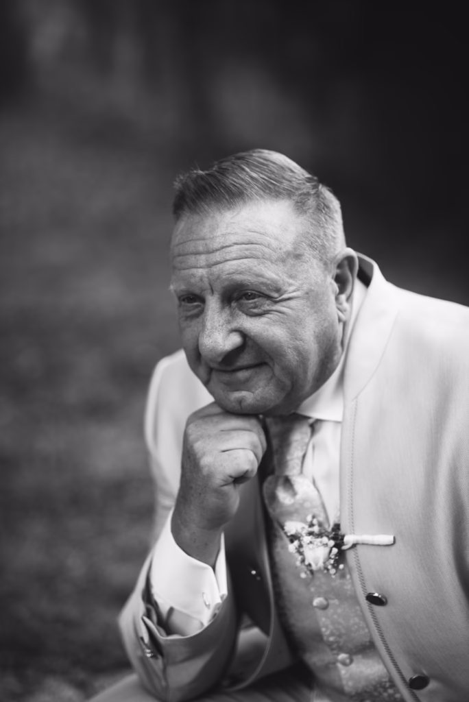 A groom posing elegantly in a perfectly tailored wedding suit, exuding confidence and sophistication, with luxury details enhancing the refined look.