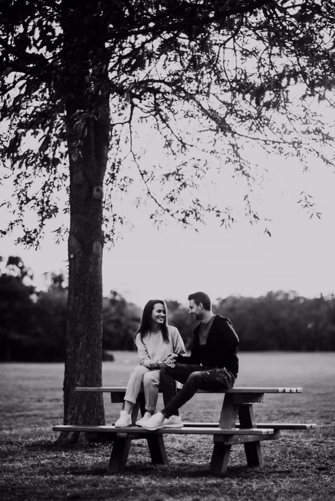 A couple sharing a romantic embrace in front of Schönbrunn Palace, elegantly dressed, with golden light highlighting the timeless beauty of their engagement shoot.