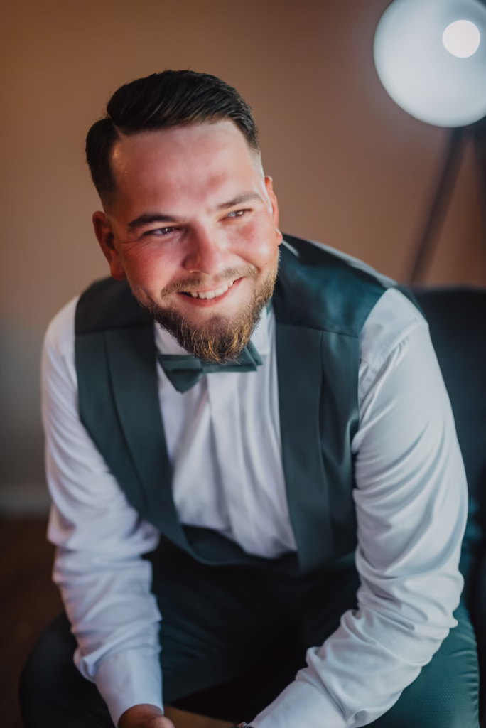 Groom adjusting his suit jacket before the wedding, captured in an elegant and timeless portrait.